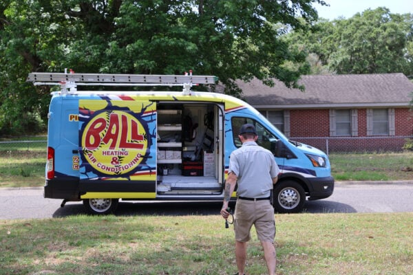 service technician shaking the hands of smiling customers for AC tune-up services